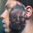 Tatuaggio col volto figlio su una guancia: sull'altra c'è ritratto un teschio02