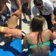 Donna esce dall'acqua con squalo appeso al braccio 8