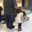 Lega capelli figlia al carrello e la trascina per il supermercato 02