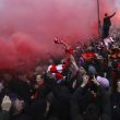 Smoke from flares engulfs some soccer fans as they gather ahead of their Champions League, Semi Final First Leg soccer match between Liverpool and Roma, at Anfield in Liverpool, England, Tuesday April 24, 2018. (Peter Byrne/PA via AP) [CopyrightNotice: PA Wire]
