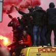 Soccer fans stand on top of a police van and light flares outside the stadium before the Champions League semifinal, first leg, soccer match between Liverpool and AS Roma at Anfield Stadium, Liverpool, England, Tuesday, April 24, 2018. (ANSA/AP Photo/Dave Thompson) [CopyrightNotice: Copyright 2018 The Associated Press. All rights reserved.]