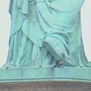 YOUTUBE New York, donna sulla Statua della Libertà. Protesta contro Trump