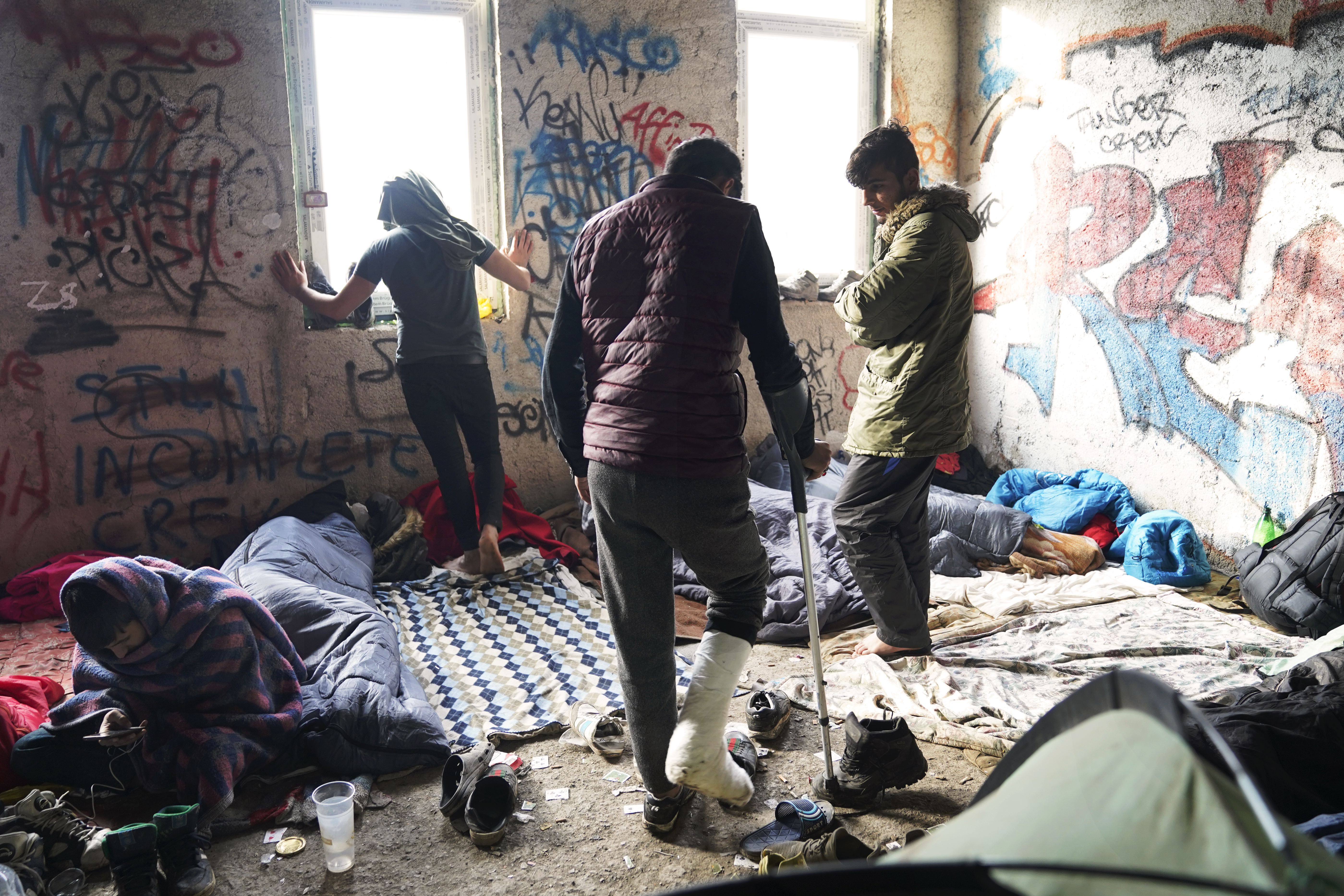 n.1: Un gruppo di ragazzi rifugiati nel centro di accoglienza provvisorio nella periferia di Bihac, uno di loro riporta una ferita alla gamba causata dallo scontro con la polizia croata (Foto di Paolo Amedei)
