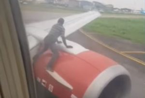 nigeria, uomo sale su ala aereo