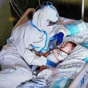 La carezza dell'infermiera al bimbo di 7 mesi malato di Covid, FOTO simbolo all'ospedale di Ancona