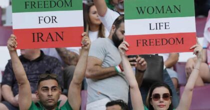Iran, i calciatori non cantano l'inno. I tifosi li insultano. Ma dalla tribuna anche cartelli a favore dei manifestanti