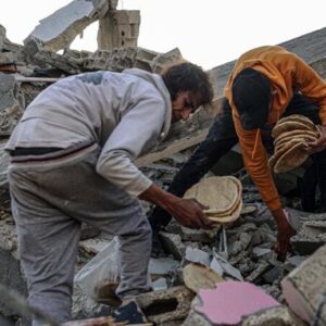 Due palestinesi raccolgono del cibo tra le rovina di Gaza FOTO ANSA