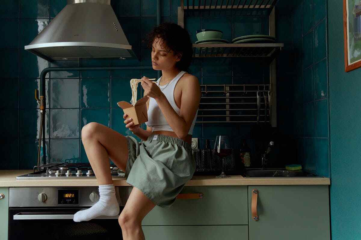 giovane donna mangia in cucina