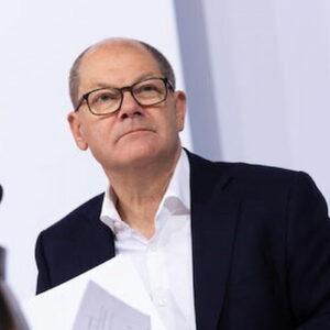 Olaf Scholz con gli occhiali legge un discorso in Germania